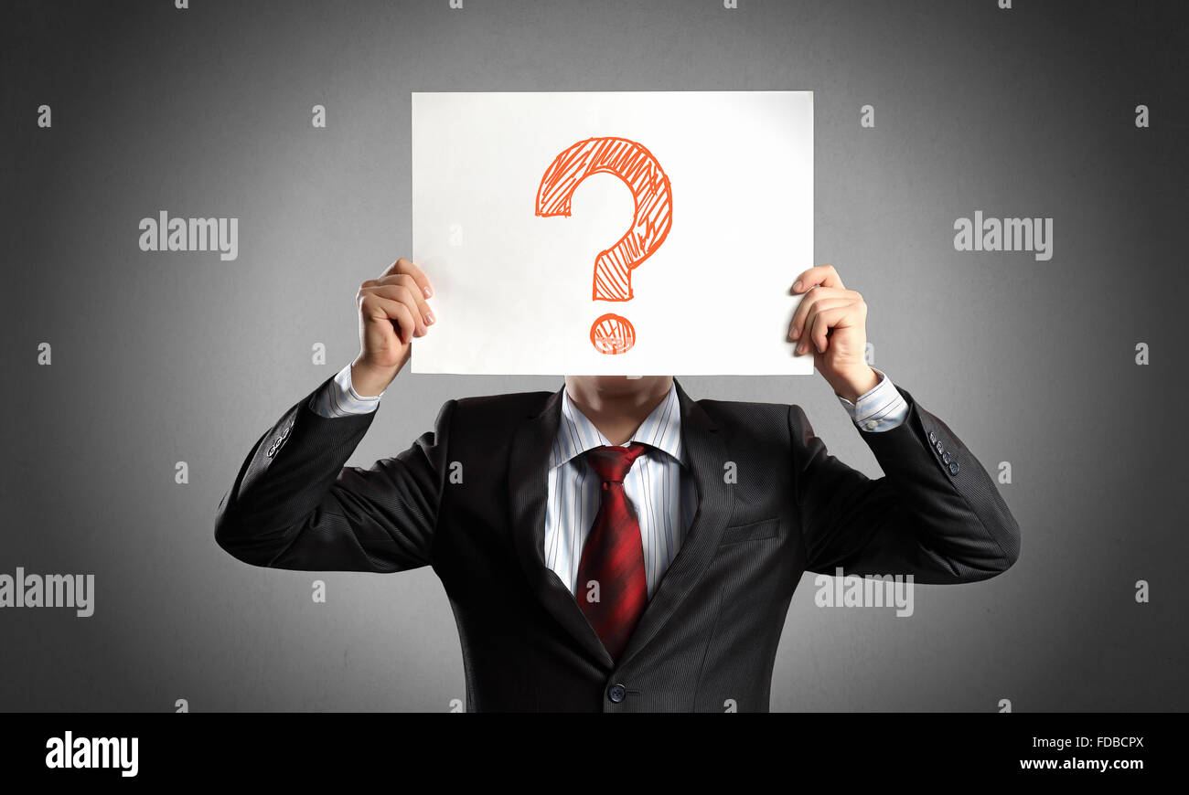 Businessman holding paper sheet with question mark in front of his face ...