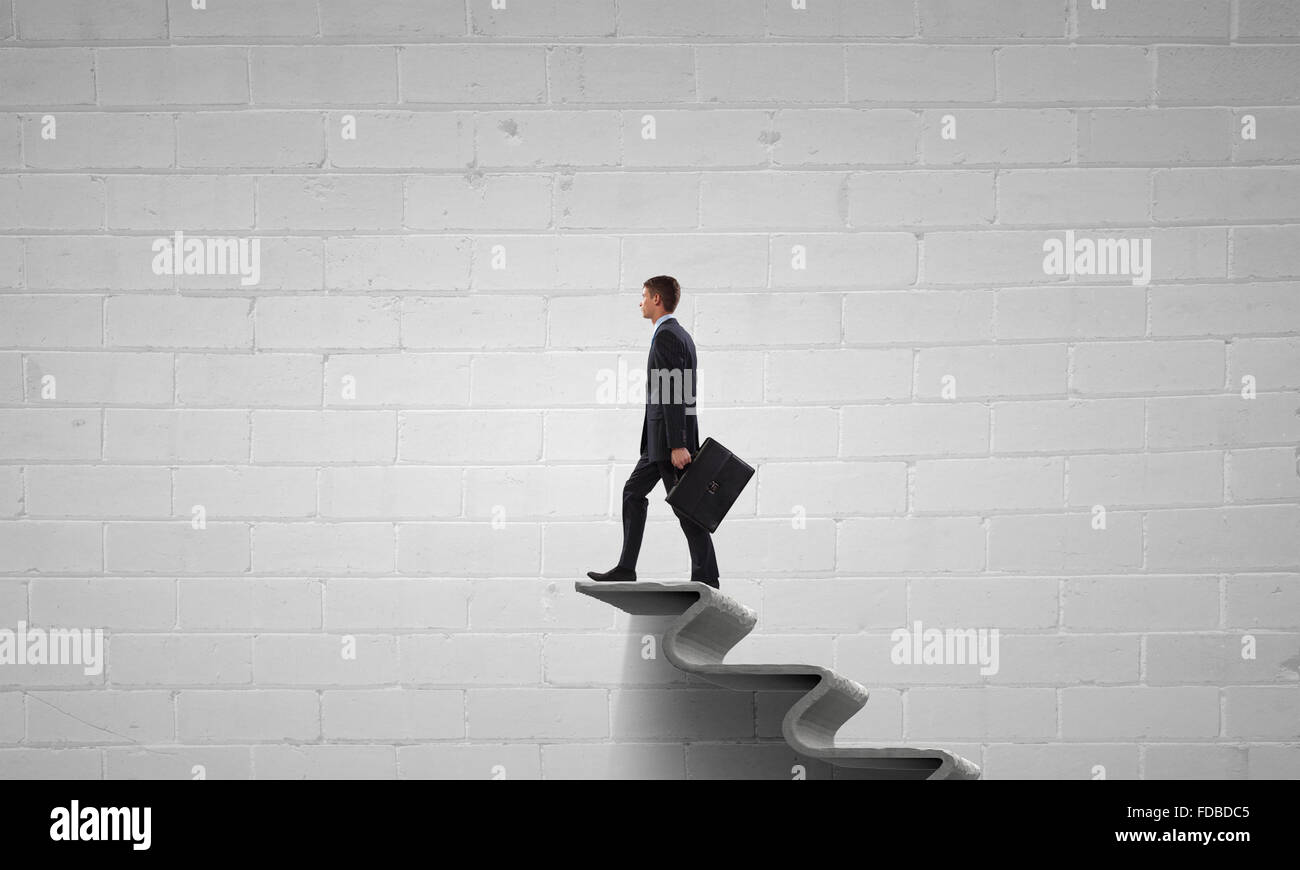Young businessman walking up on staircase representing success concept ...