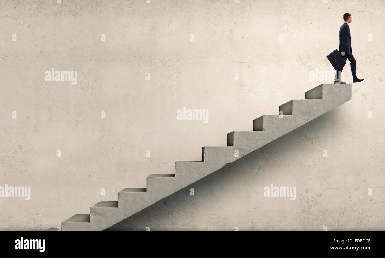 Young businessman walking up on staircase representing success concept ...