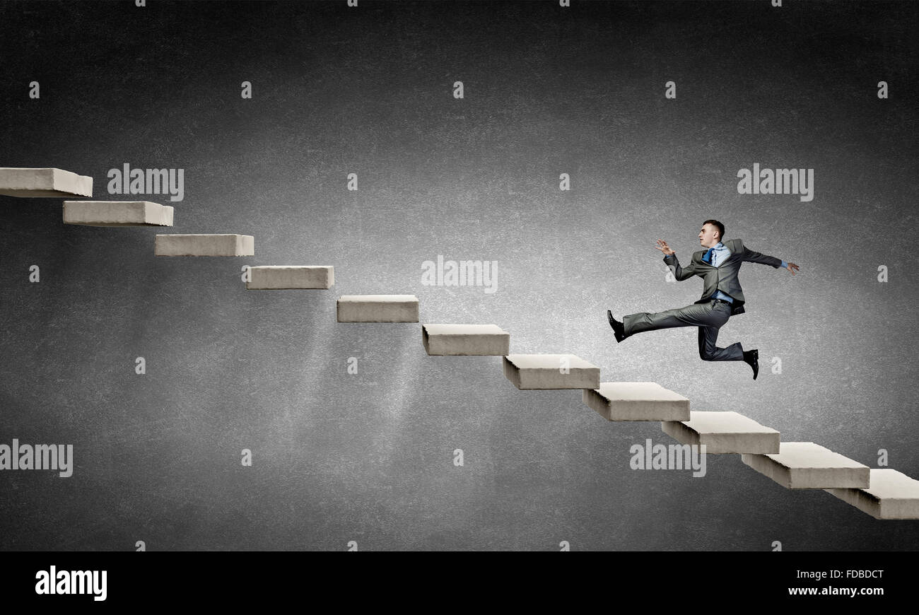 Young businessman running up on staircase representing success concept ...
