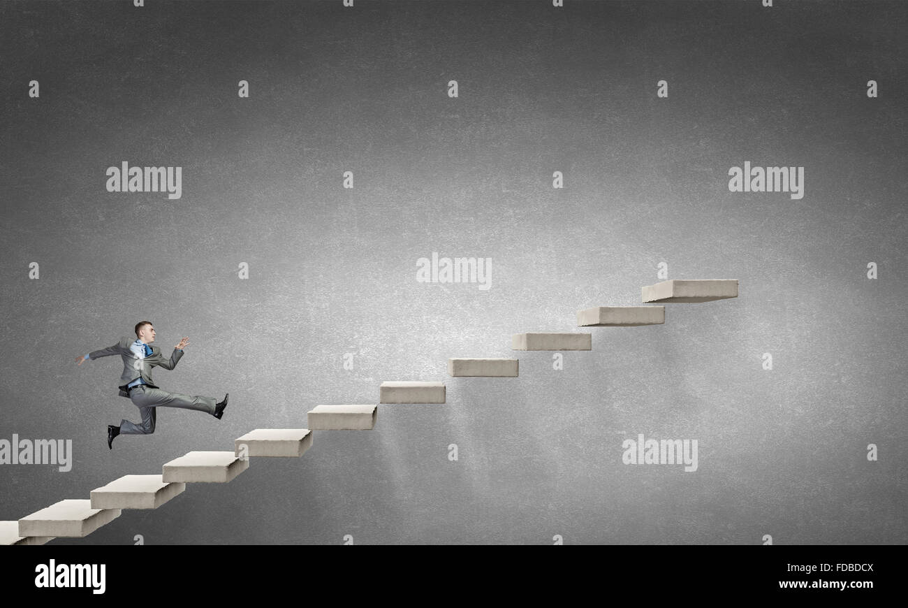 Young businessman running up on staircase representing success concept ...