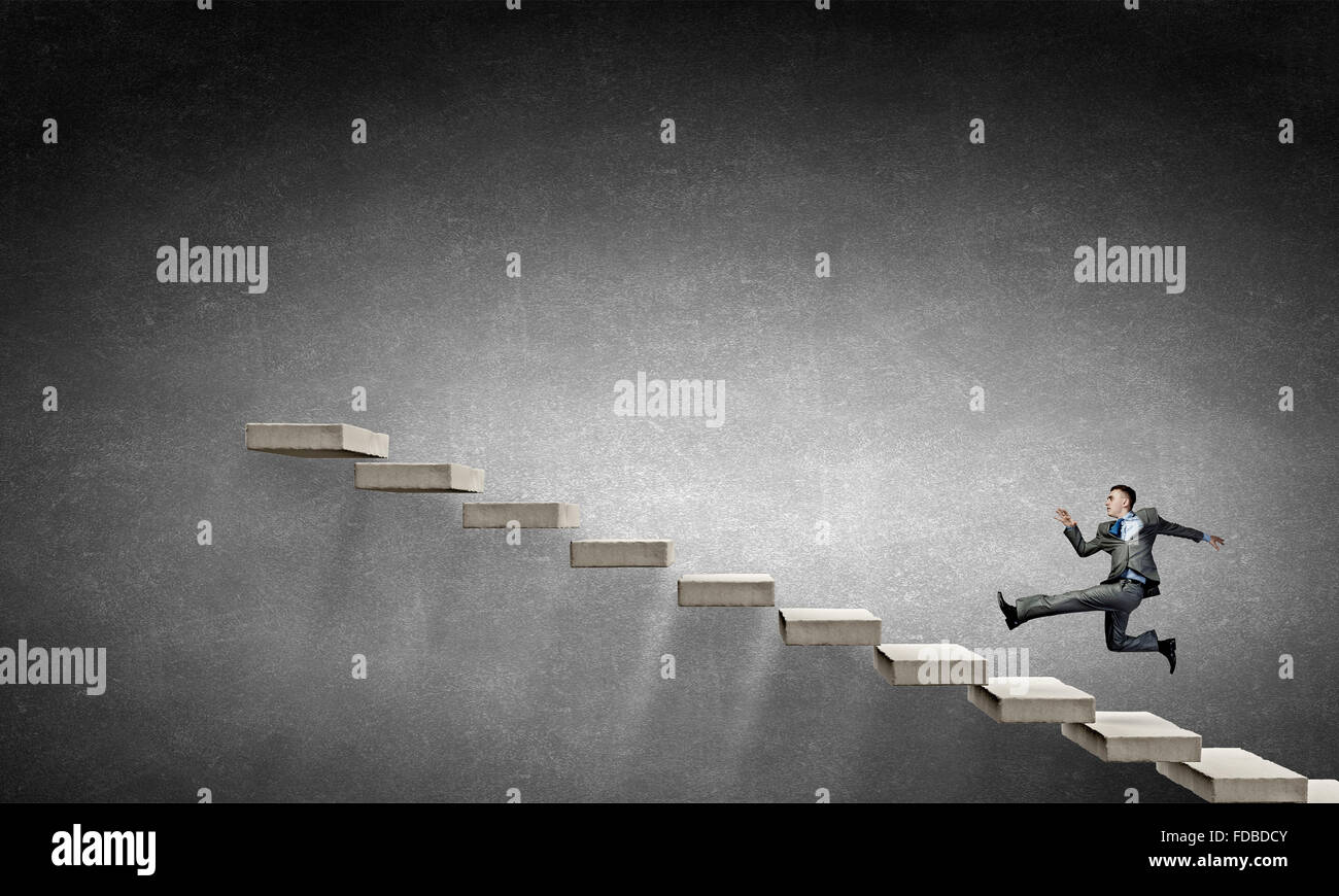 Young businessman running up on staircase representing success concept ...