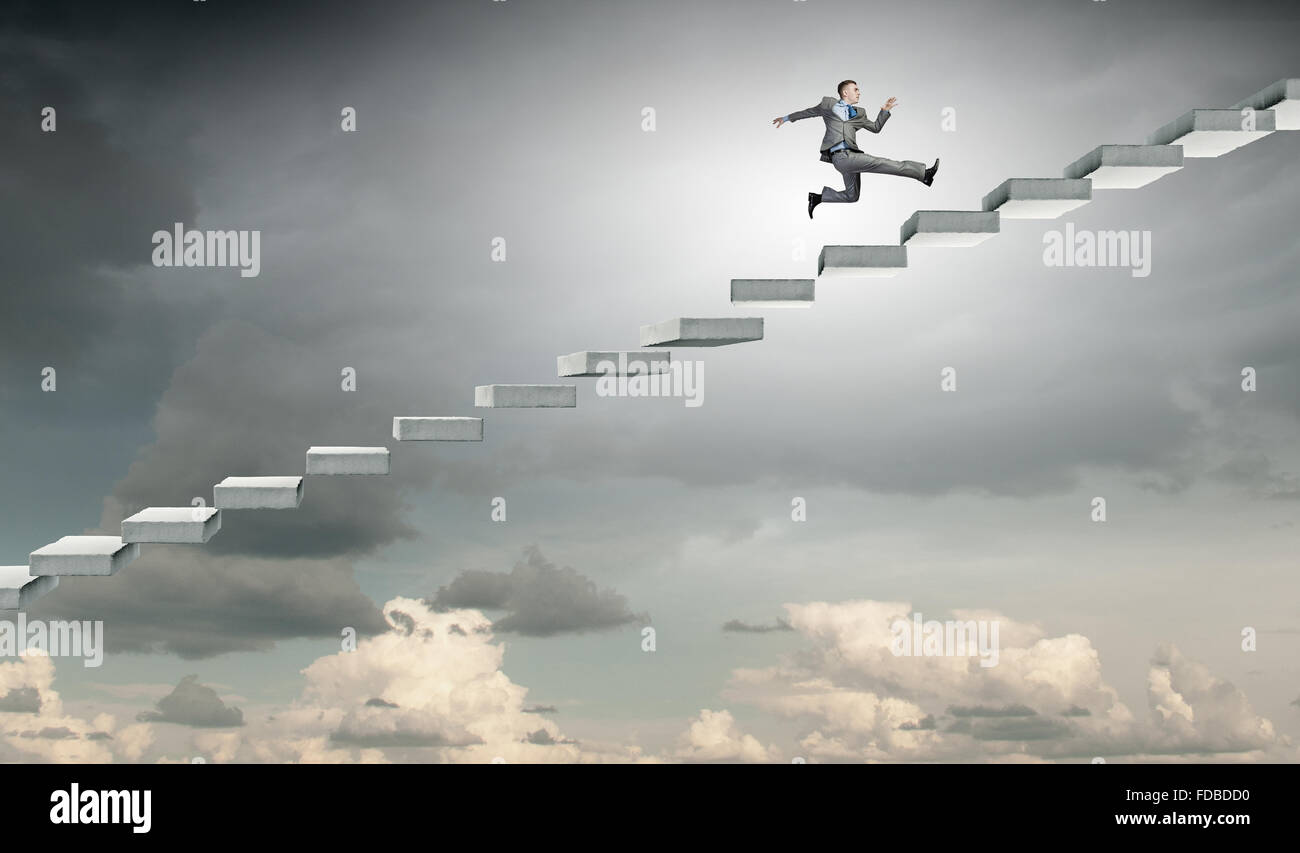 Young businessman running up on staircase representing success concept ...
