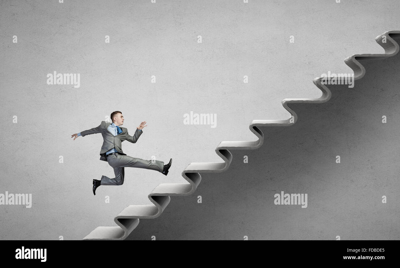 Young businessman running up on staircase representing success concept ...