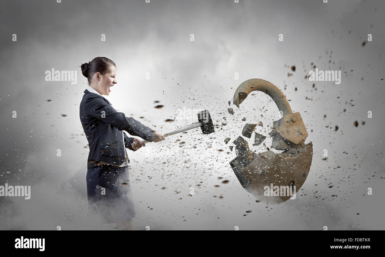 Young angry businesswoman crashing stone lock with hammer Stock Photo ...