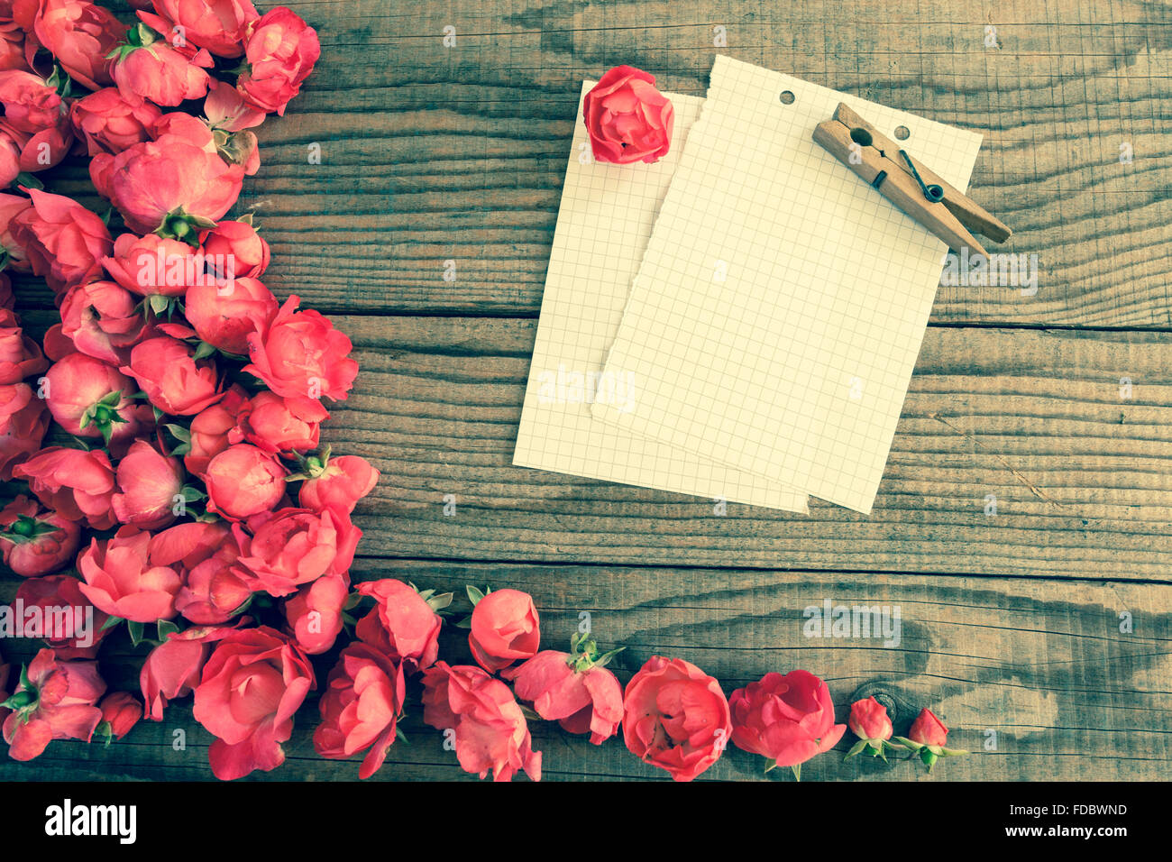 block notes and red roses on wooden background, vintage denim effect ...