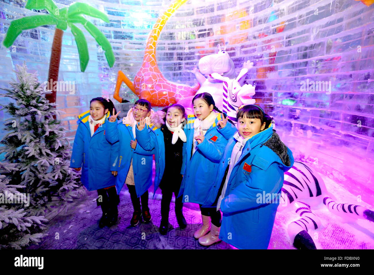 (160130) -- RUIAN (ZHEJIANG), Jan. 30, 2016 (Xinhua) -- Children pose with ice sculptures of cartoon images at an indoor ice sculpture exhibition in Ruian City, east China's Zhejiang Province, Jan. 30, 2016. (Xinhua/Zhuang Yingchang) (wyl) Stock Photo