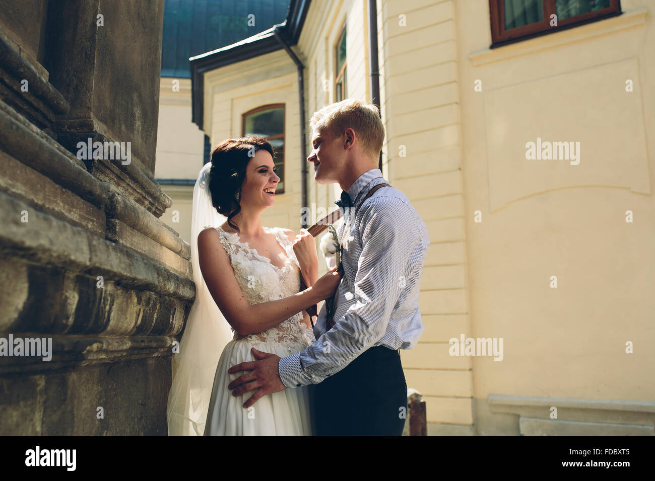 The bride and groom posing in the old street Stock Photo - Alamy