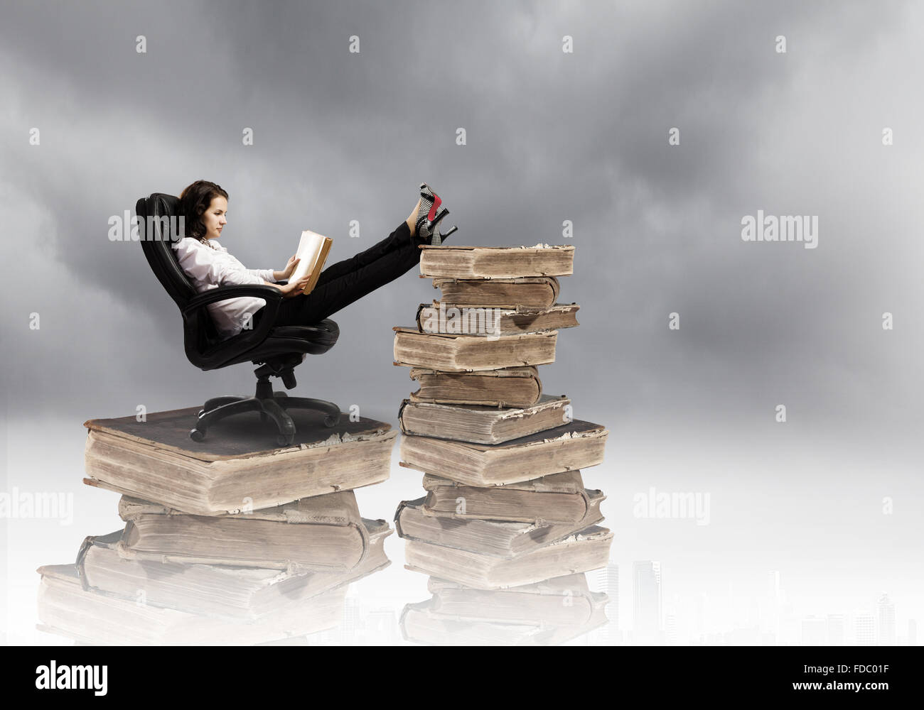 Young businesswoman sitting in chair and reading book Stock Photo - Alamy