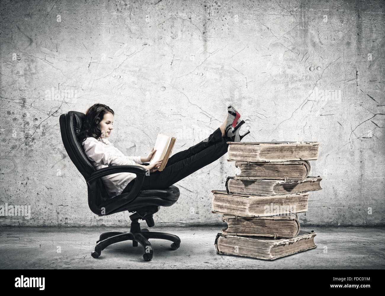 Young businesswoman sitting in chair and reading book Stock Photo - Alamy