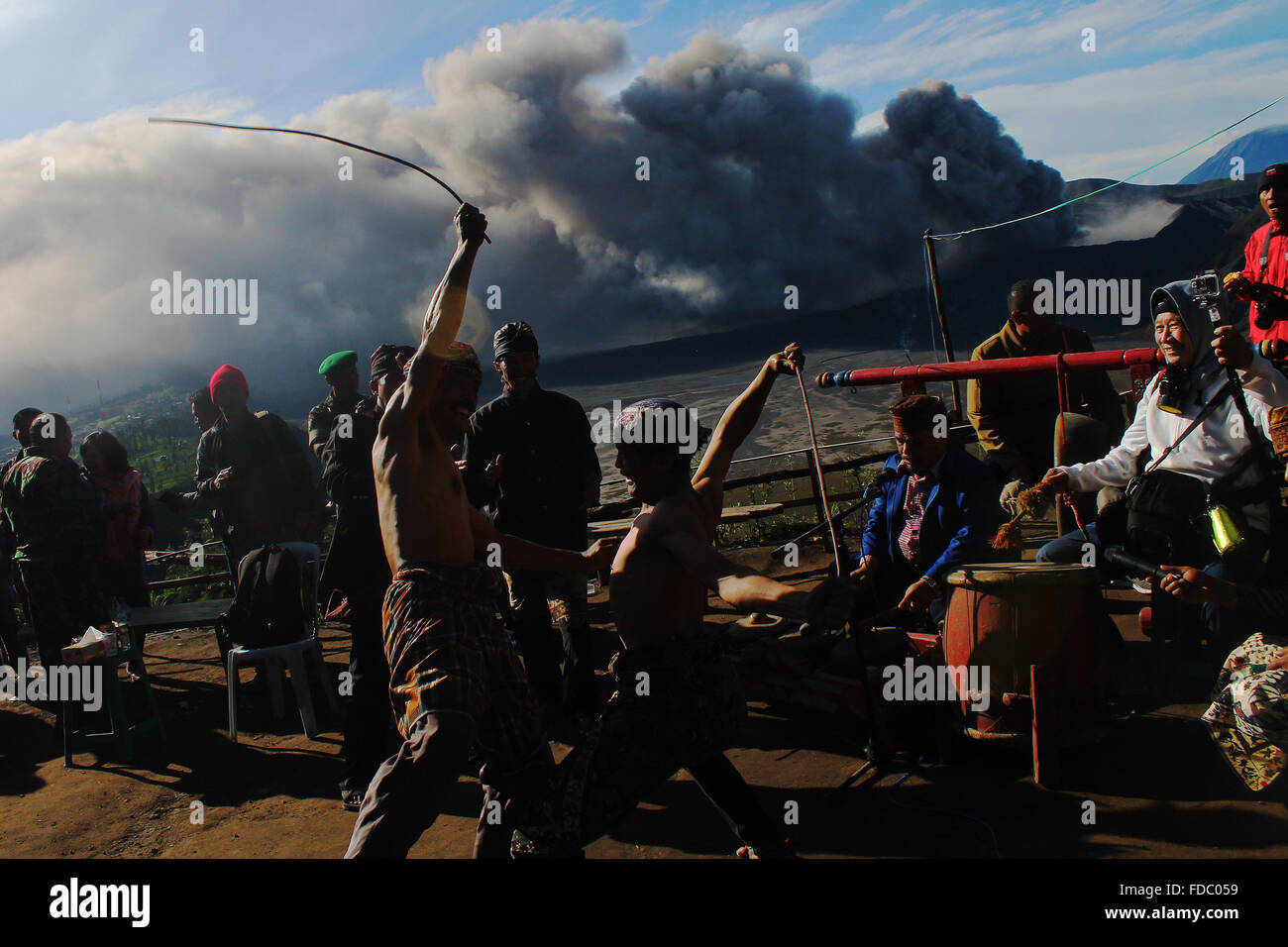 Probolinggo, EAST JAVA, INDONESIA. 30th Jan, 2016. Tenggerese performs a traditional dance called ''Ujung-Ujungan'' while the eruption of Mount Bromo in Probolinggo, East Java, on January 30, 2016. The ''Ujung-Ujung'' dance is one of the traditional dance and sports a distinctive combination of Tengger tribe, in the region of Mount Bromo in Probolinggo, East Java. This dance is played by two men who alternated hitting the opponent by using rattan. Credit:  Suryanto/ZUMA Wire/Alamy Live News Stock Photo