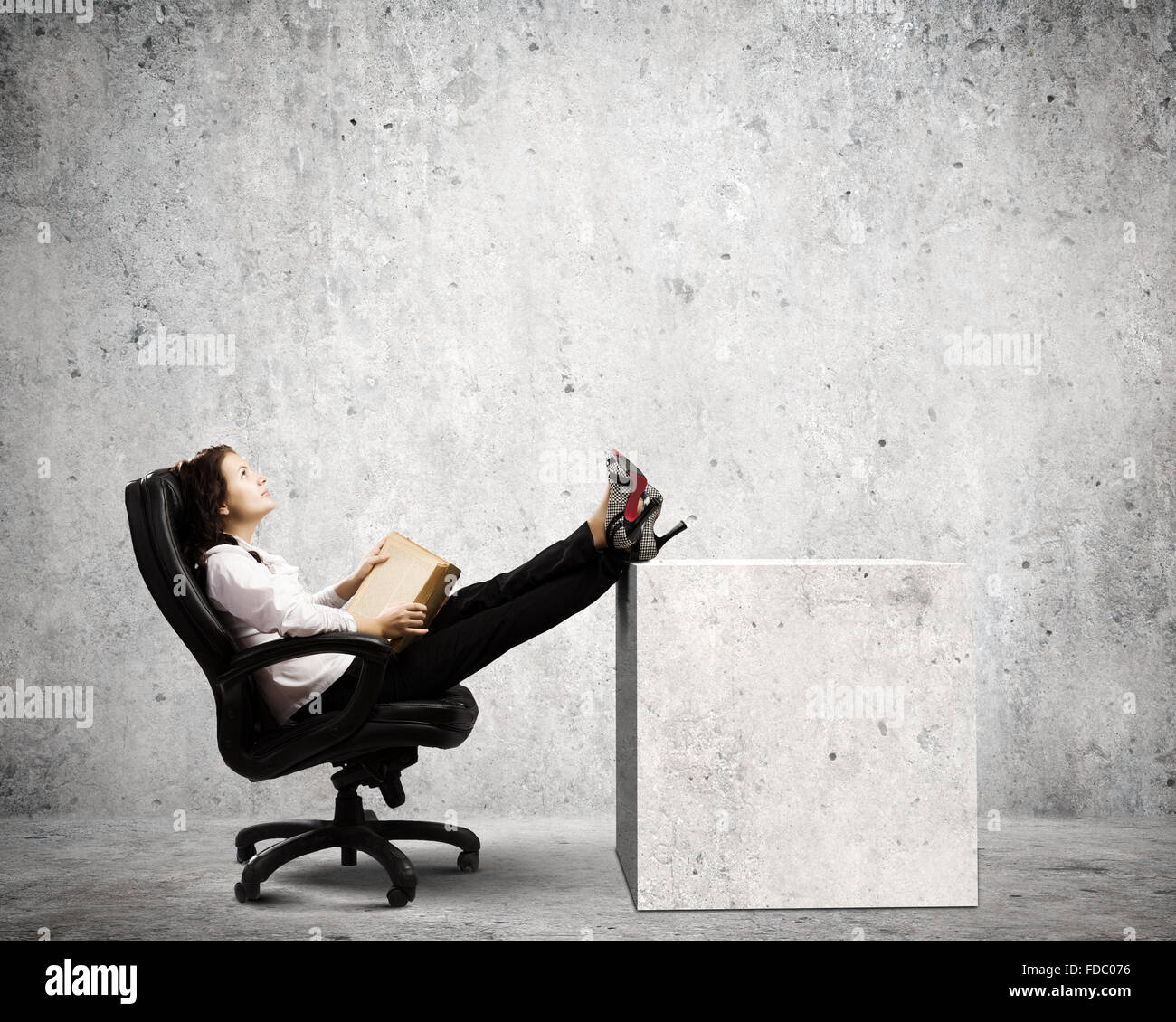 Young businesswoman sitting in chair and reading book Stock Photo - Alamy
