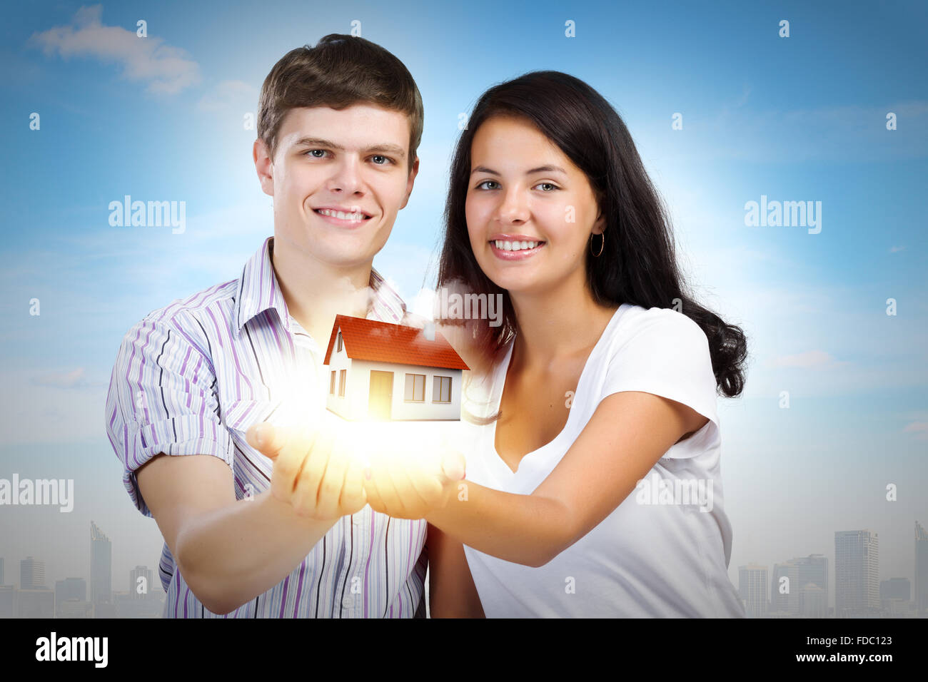 Happy young couple holding model of house on palms Stock Photo - Alamy