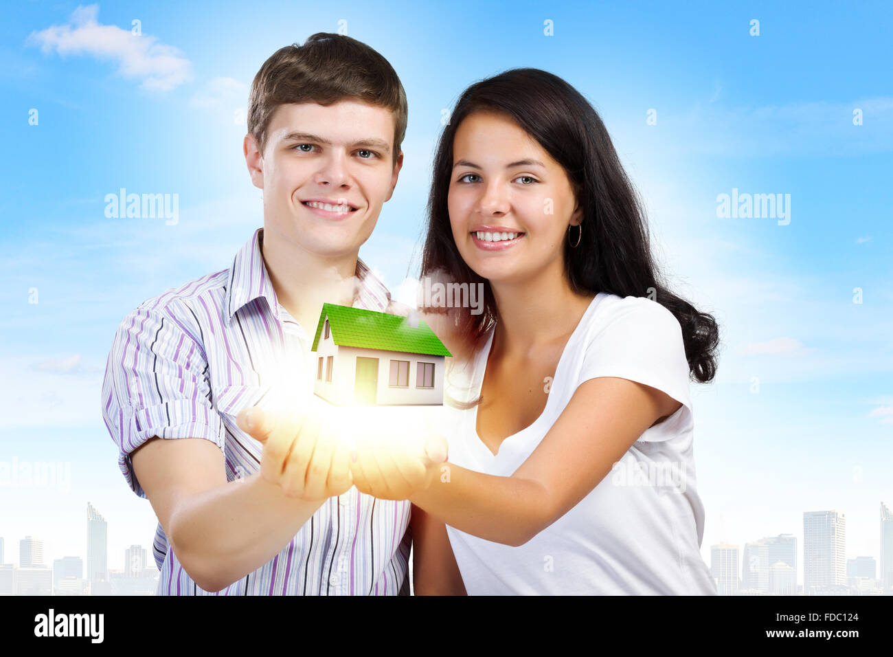 Happy young couple holding model of house on palms Stock Photo - Alamy