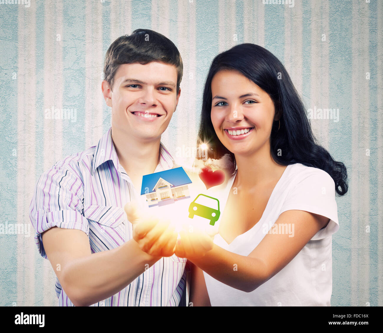 Happy young couple holding model of house on palms Stock Photo - Alamy