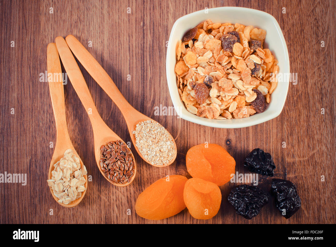 Vintage photo, Linseed, rye flakes and oat bran on spoon, dried fruits