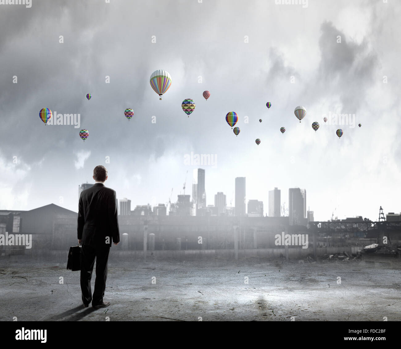 Rear view of businessman looking at aerostats flying above city Stock ...