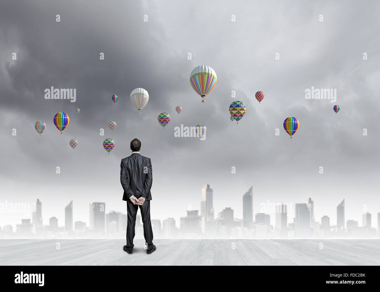 Rear view of businessman looking at aerostats flying above city Stock ...