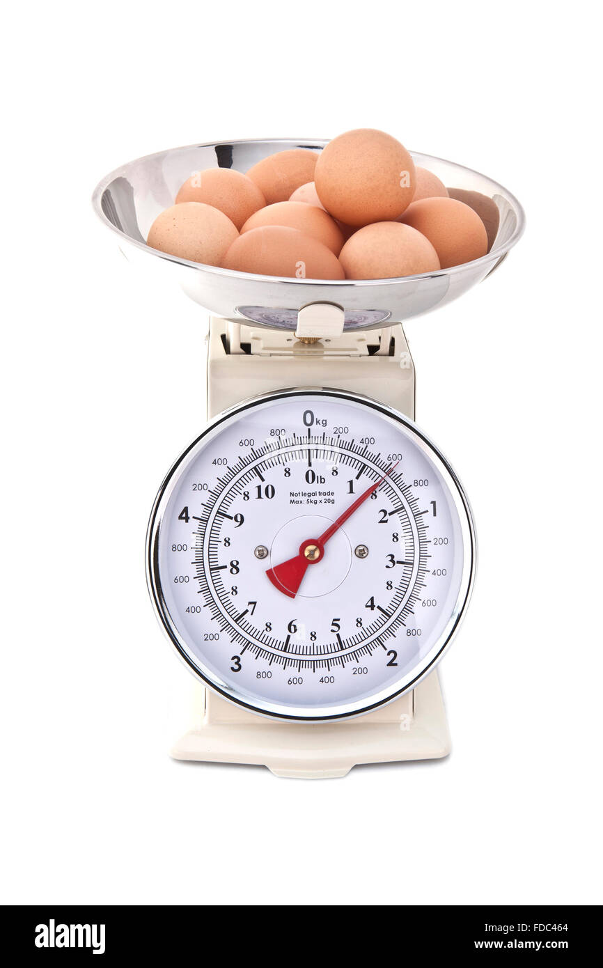 Kitchen Scales with fresh eggs on white background Stock Photo
