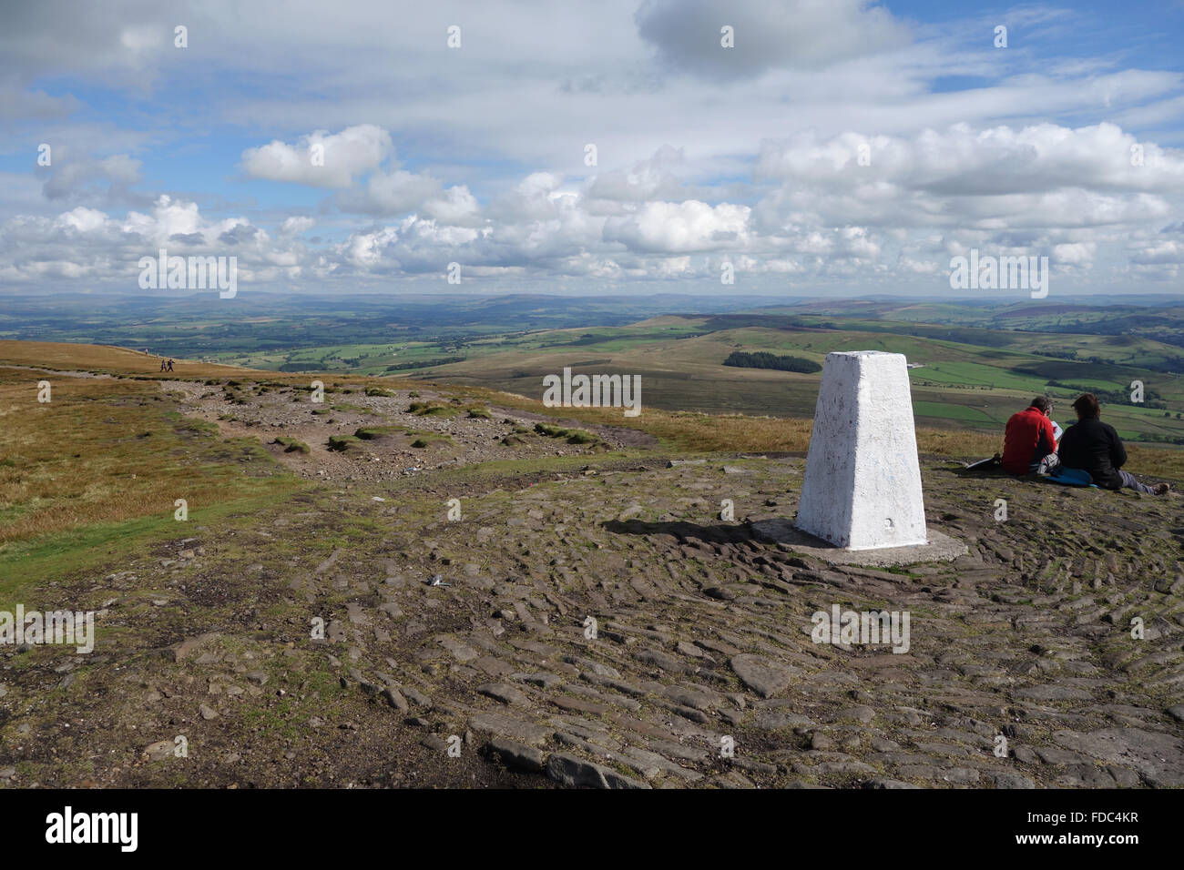 Walkers at  Trig point at summit of Pendle Hill in Lancashire Stock Photo