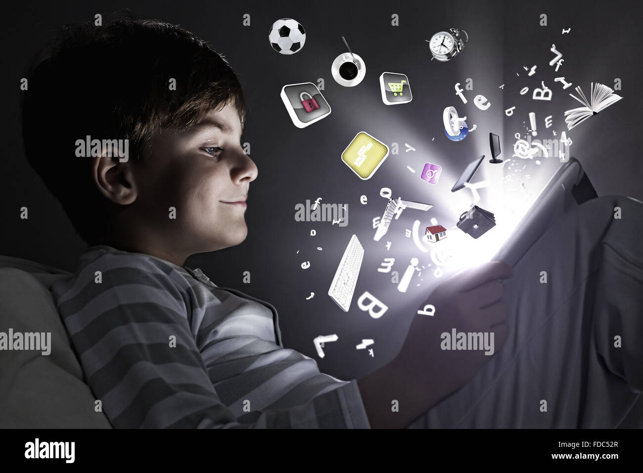 Cute little boy sitting in bed and using tablet pc Stock Photo - Alamy