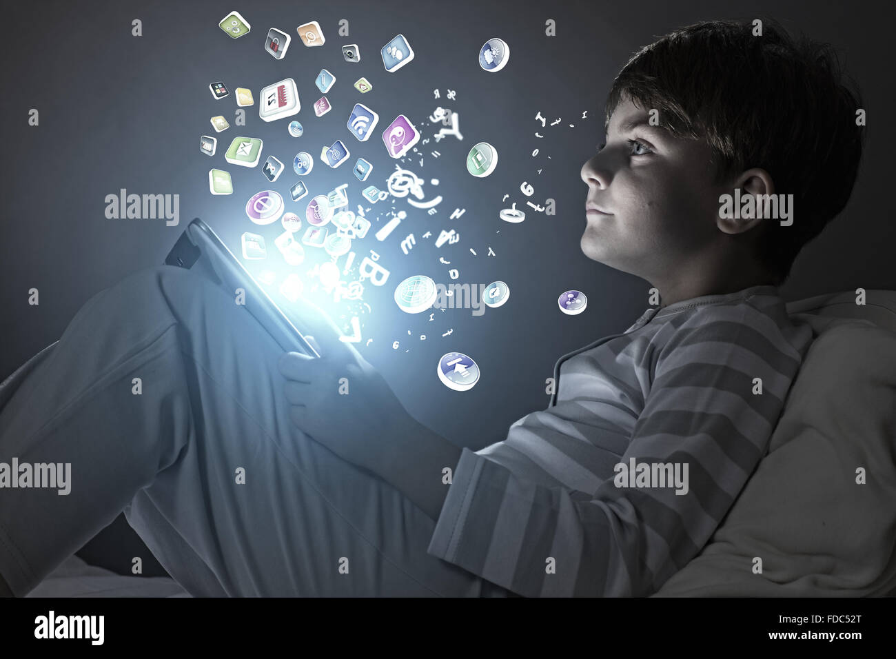Cute little boy sitting in bed and using tablet pc Stock Photo - Alamy