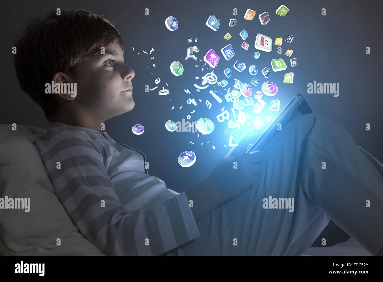 Cute little boy sitting in bed and using tablet pc Stock Photo - Alamy