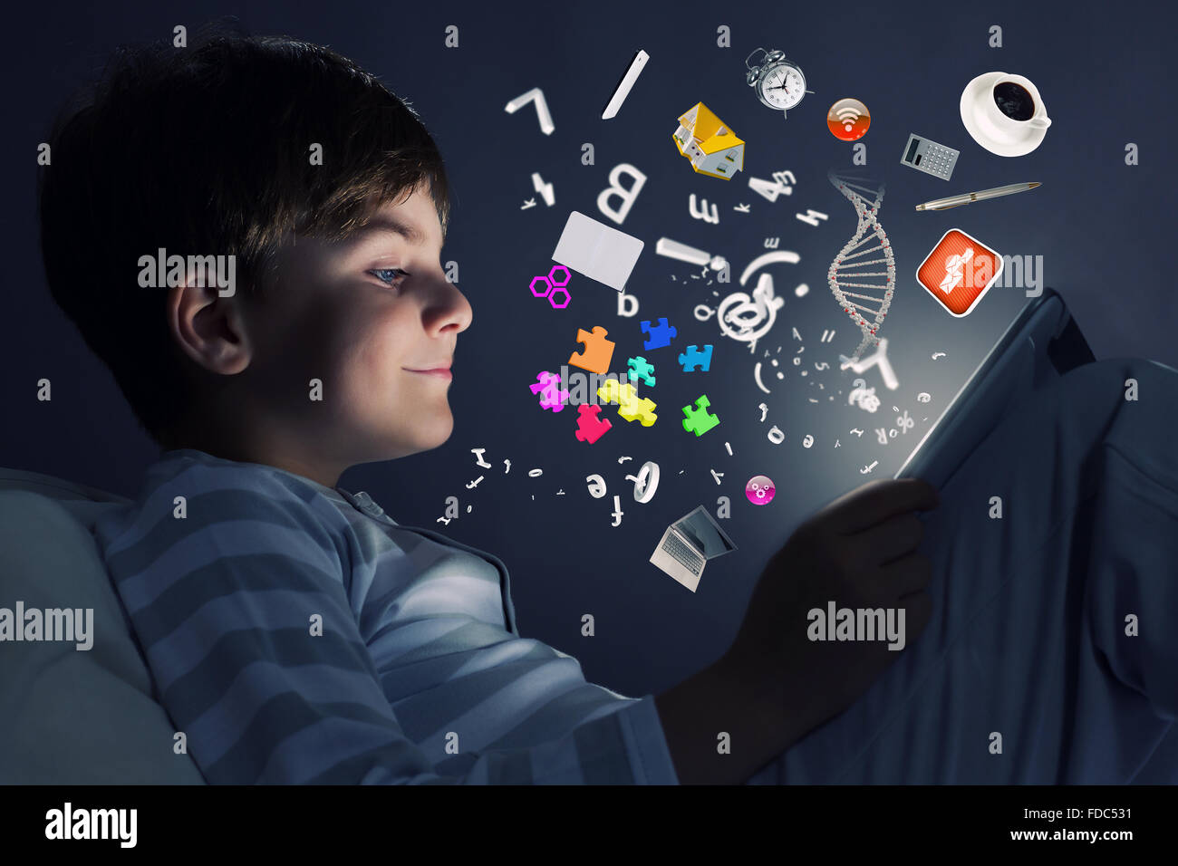 Cute little boy sitting in bed and using tablet pc Stock Photo - Alamy