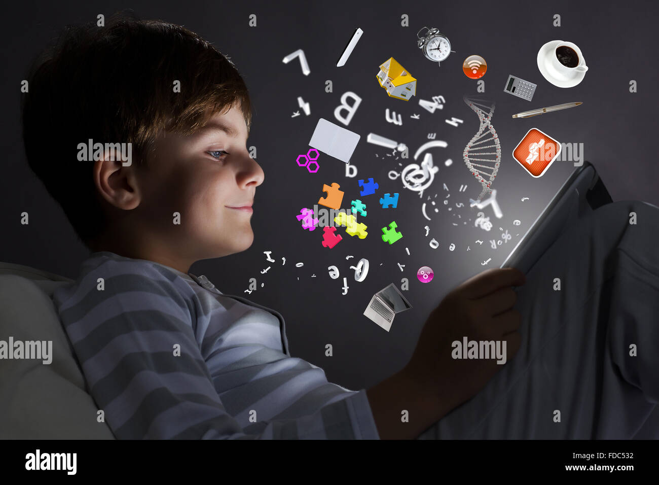 Cute little boy sitting in bed and using tablet pc Stock Photo - Alamy