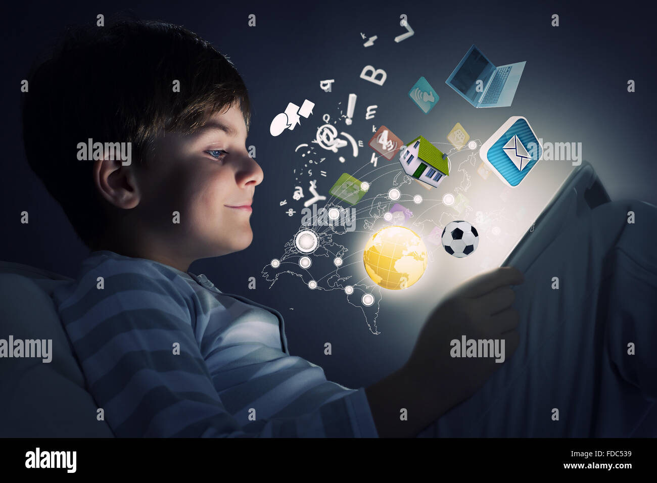 Cute little boy sitting in bed and using tablet pc Stock Photo - Alamy