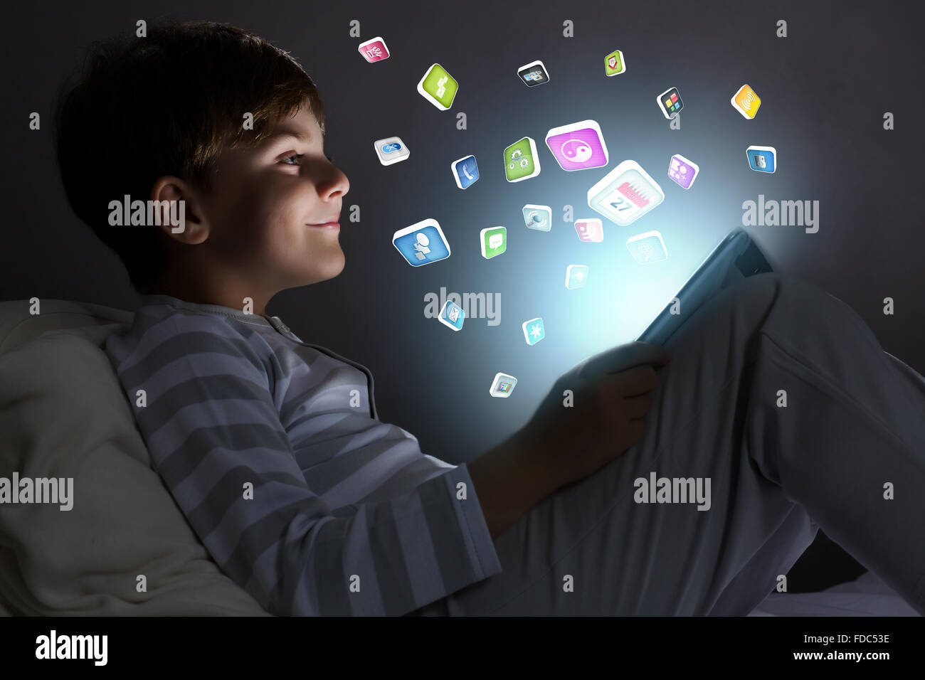 Cute little boy sitting in bed and using tablet pc Stock Photo - Alamy