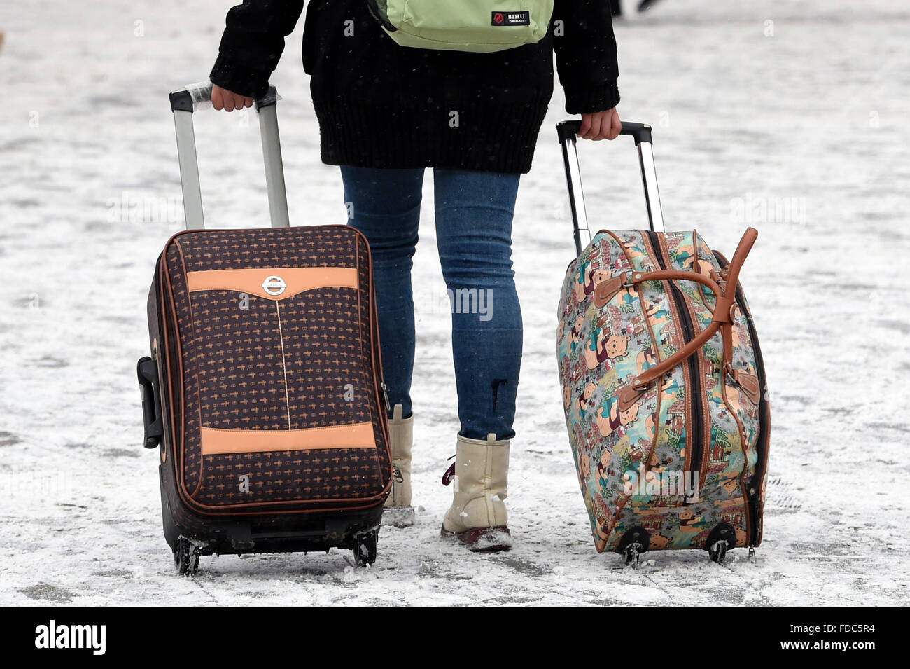Zhengzhou, China's Henan Province. 30th Jan, 2016. A passenger walks with luggage amid snow at the railway station of Zhengzhou, capital of central China's Henan Province, Jan. 30, 2016. This year's 'Chunyun', the hectic travel period surrounding Chinese Lunar New Year, or Spring Festival, began on Jan. 24. © Li Bo/Xinhua/Alamy Live News Stock Photo
