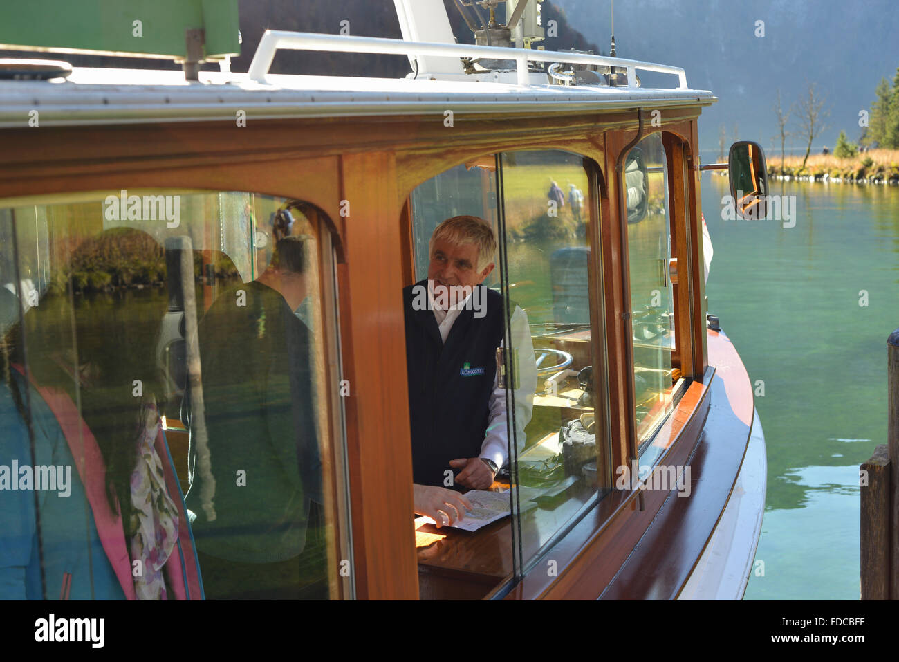 Skipper of  a cruise boat on lake Känigssee in the Berchtesgaden mountains talking to passengers at St Bartholomae,Bavaria Stock Photo
