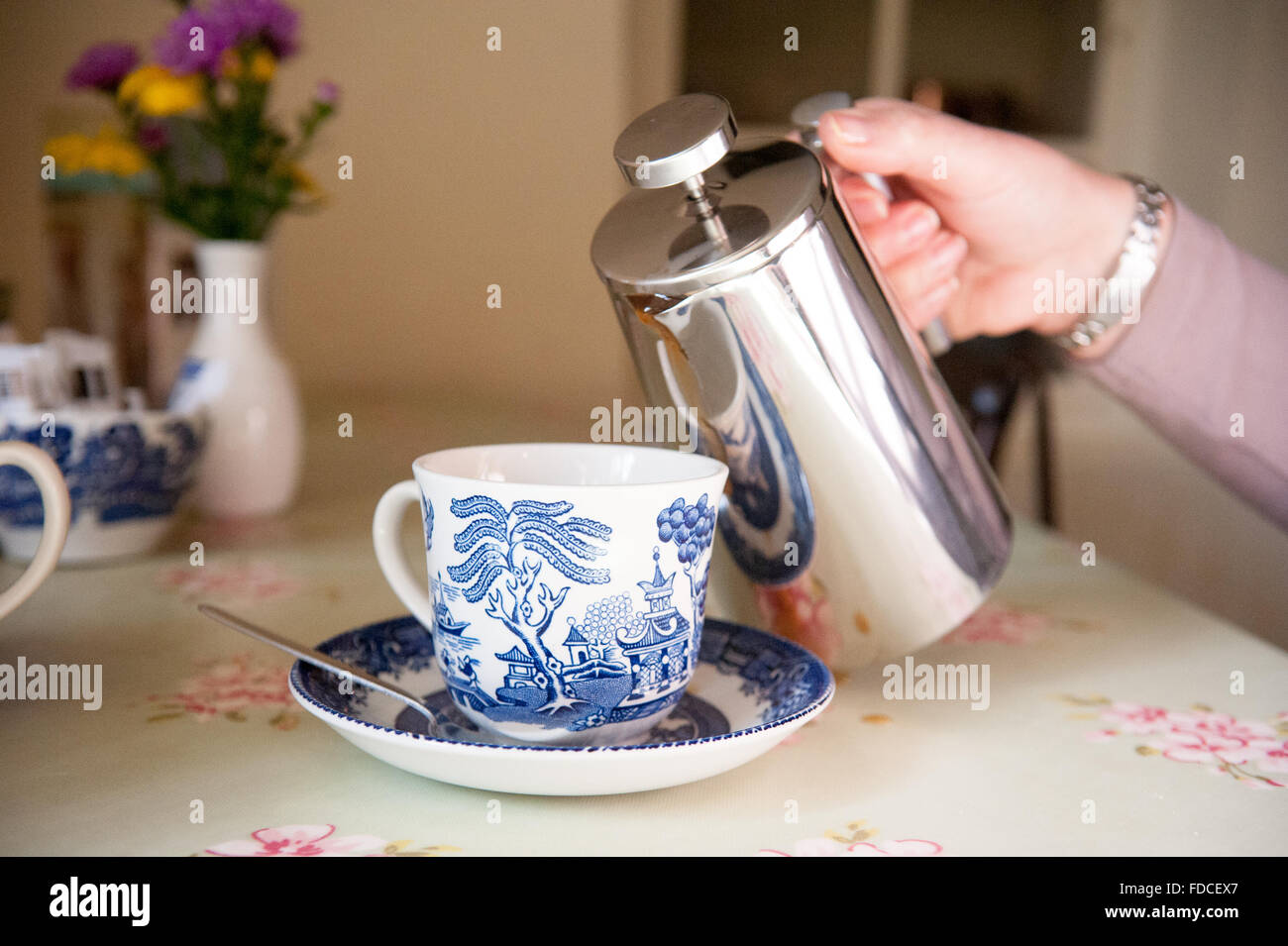Pouring tea into bone china tea cup and saucer at Drum Castle in Aberdeenshire, Scotland. Stock Photo