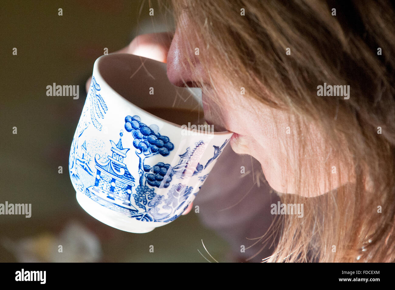 Woman drinking from bone china tea cup and saucer at Drum Castle in