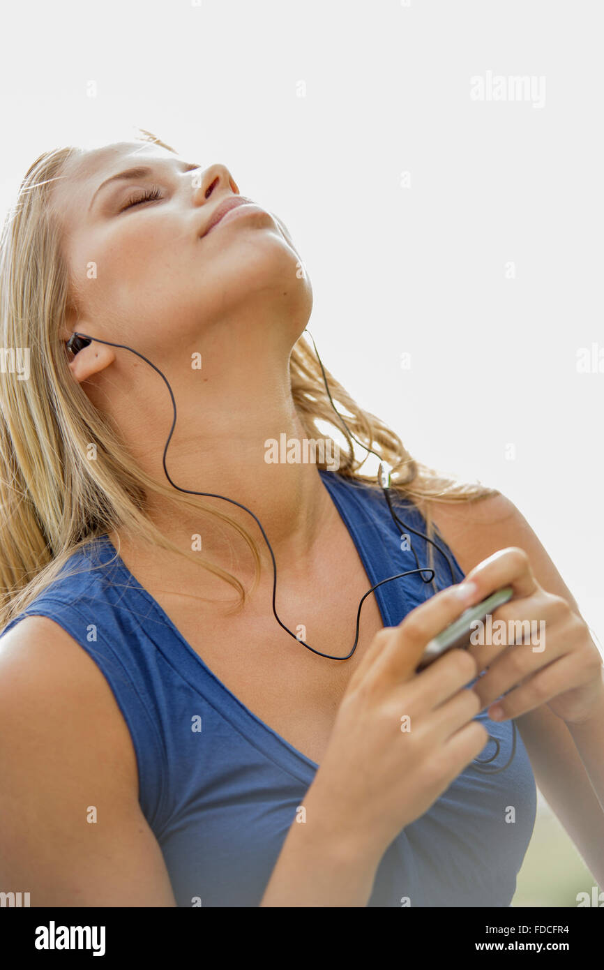 Portrait of young blond woman with MP3 Player listening to music Stock ...