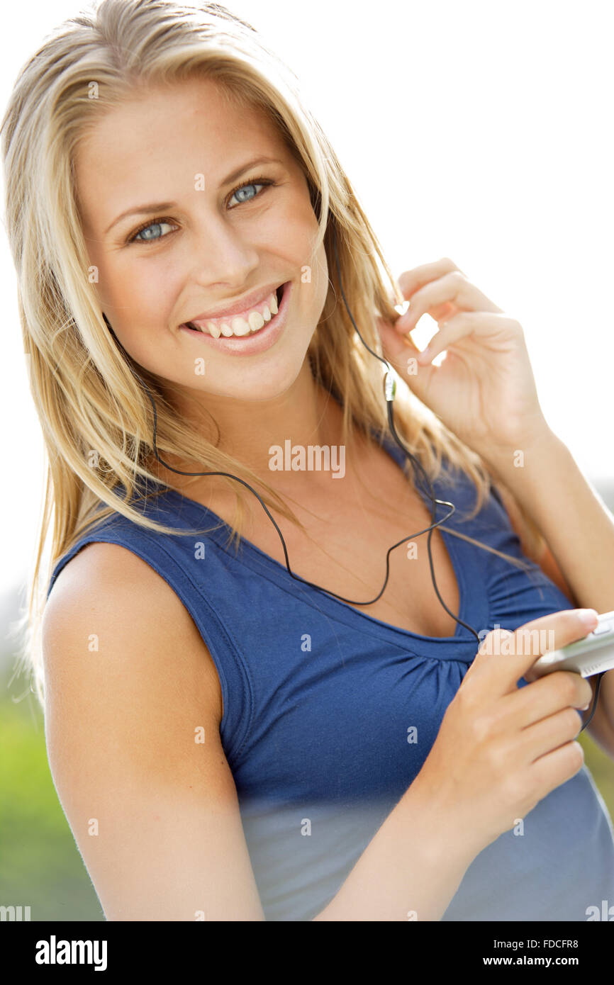 Portrait of young blond woman with MP3 Player listening to music Stock ...