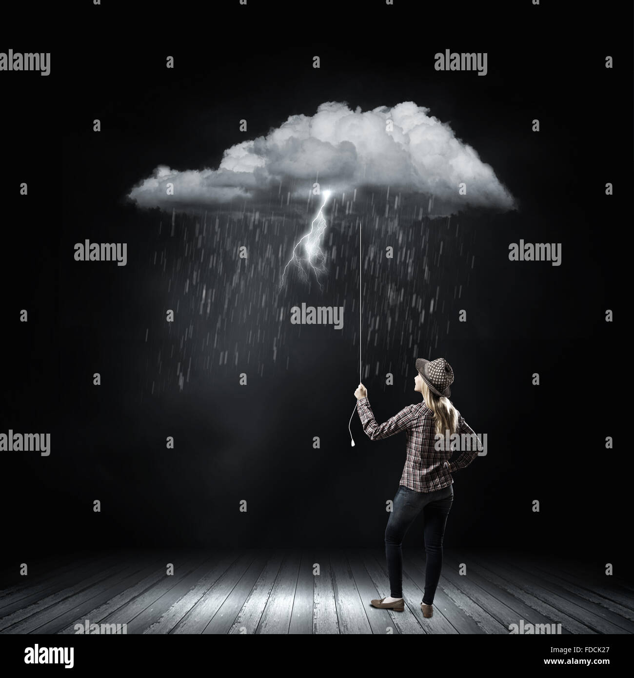 Young woman in casual holding raining cloud on rope Stock Photo - Alamy