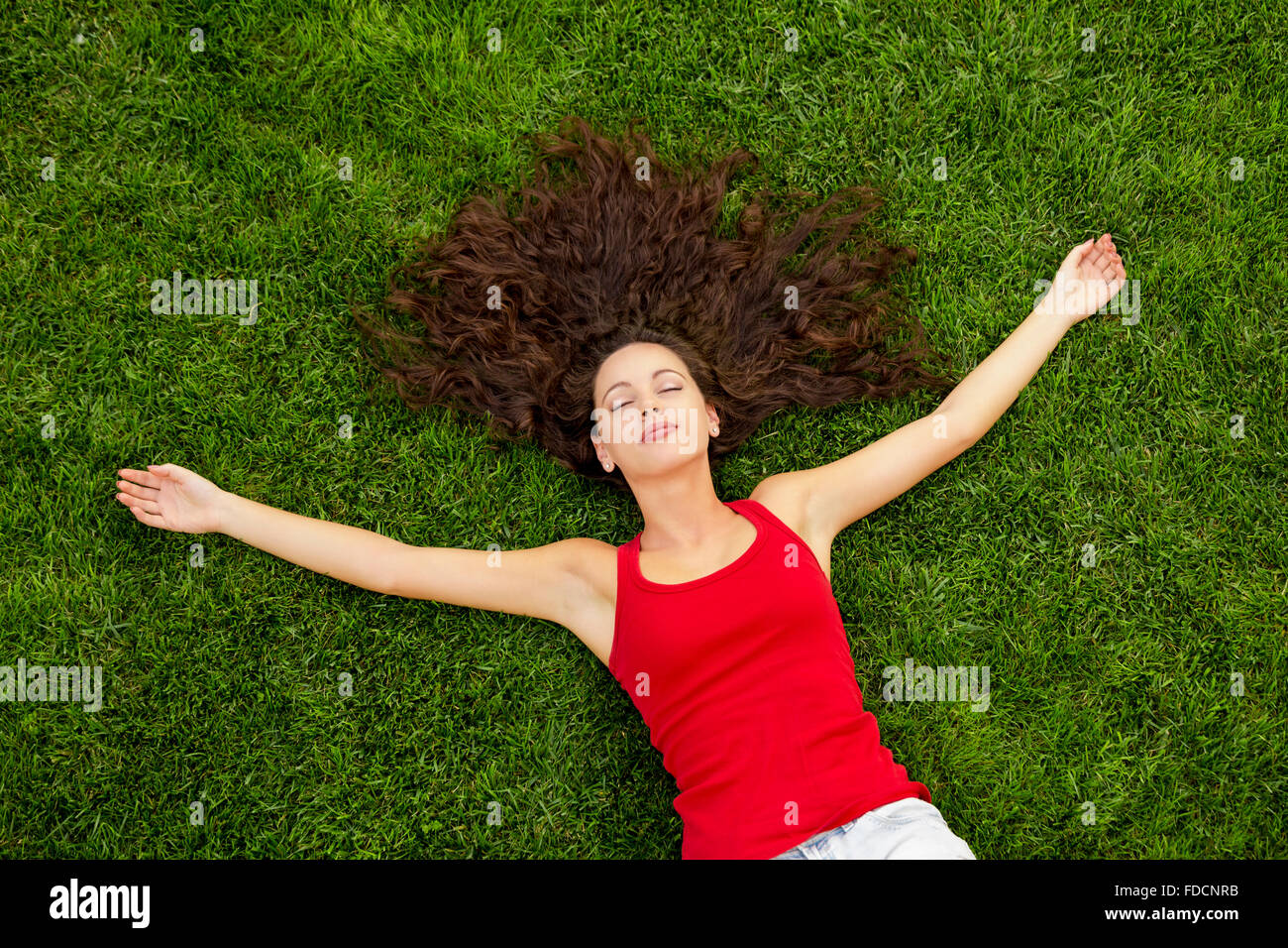 Outdoor portrait of a beautiful young woman lying on the grass Stock ...