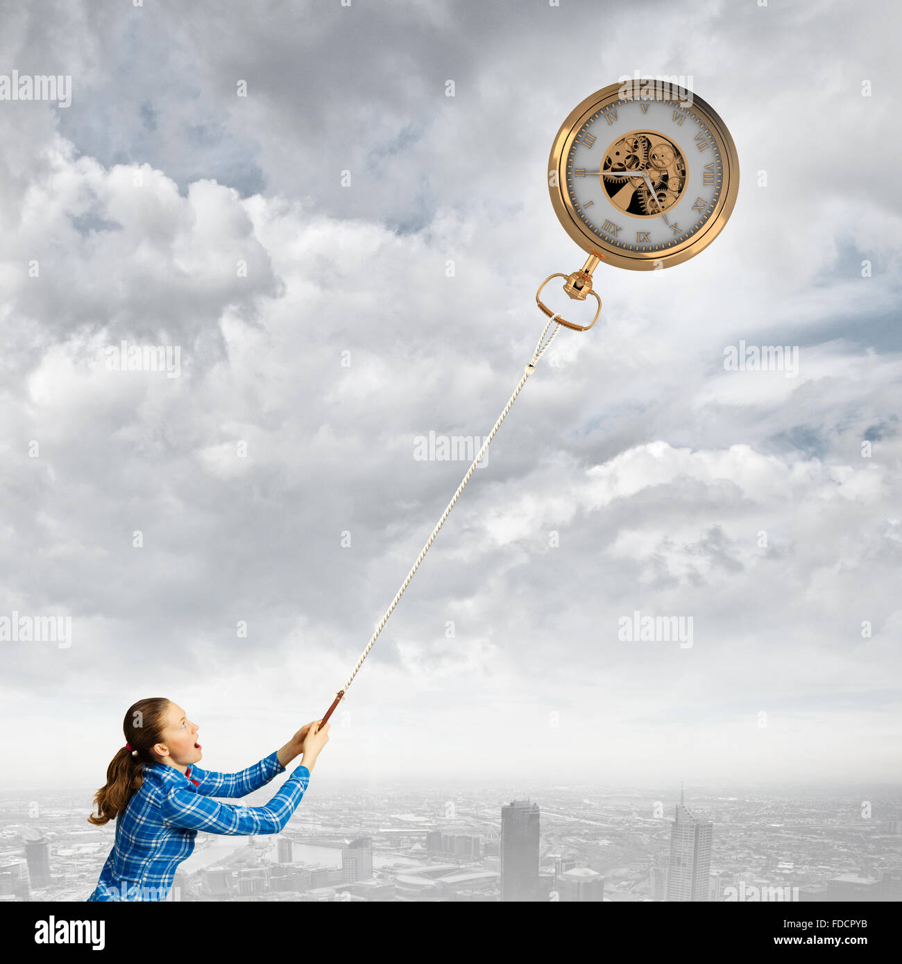 Young woman in casual catching clock with rope Stock Photo - Alamy