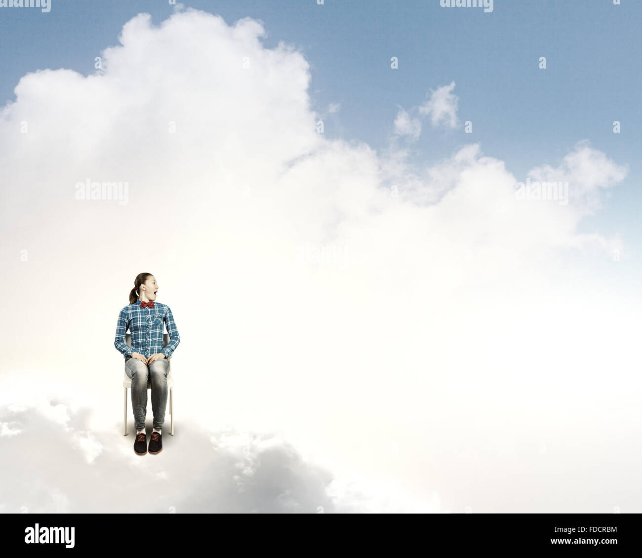Young woman sitting in chair on cloud high in sky Stock Photo - Alamy