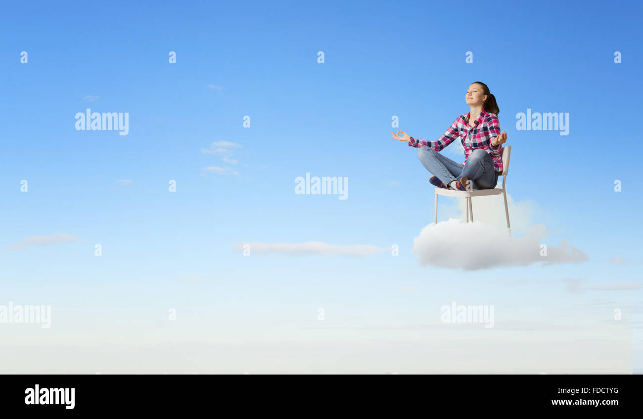 Young woman sitting on chair and meditating Stock Photo - Alamy