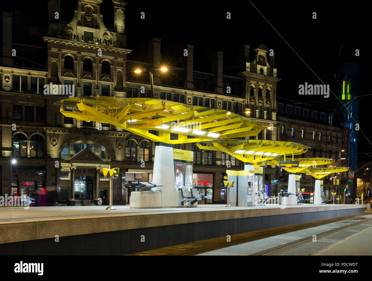 Exchange Square Metrolink tram stop at night, Corporation Street, Manchester, England, UK.  The Corn Exchange building behind. Stock Photo