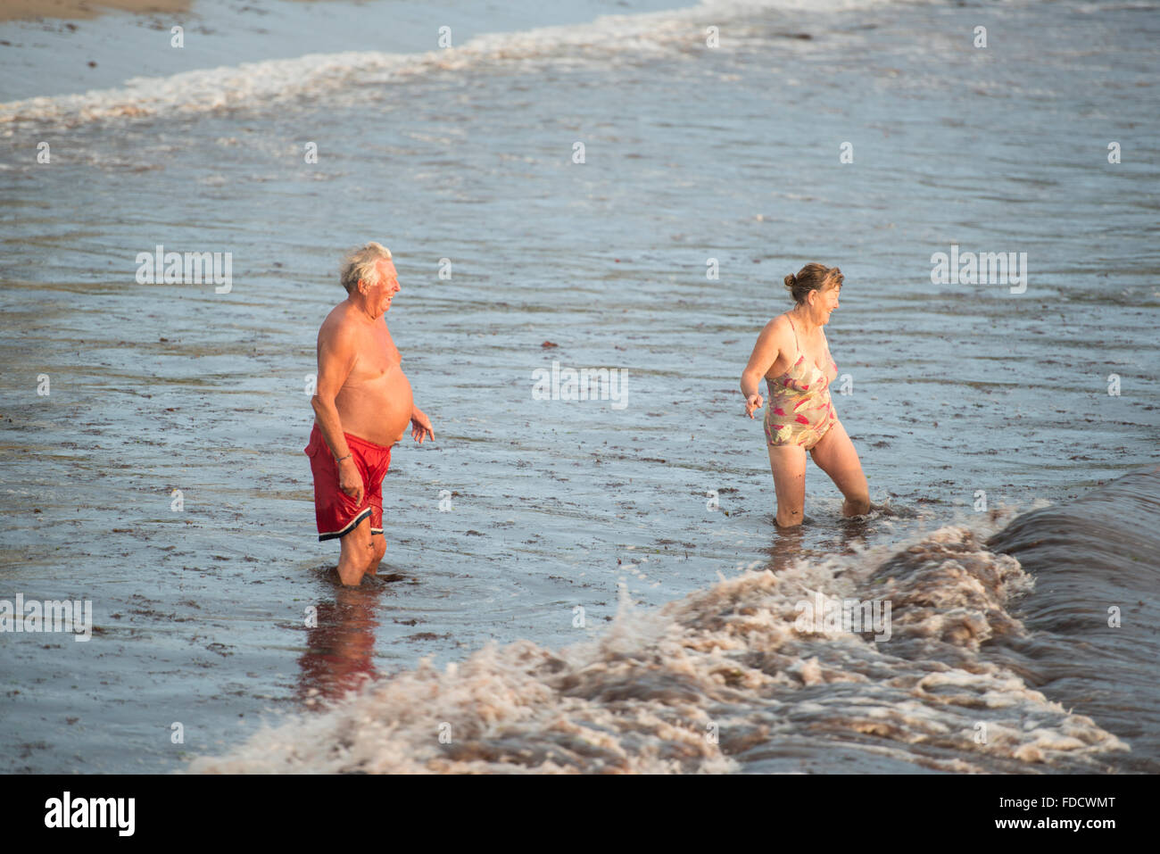 Mature couple enjoy early morning swim at Swanage Stock Photo