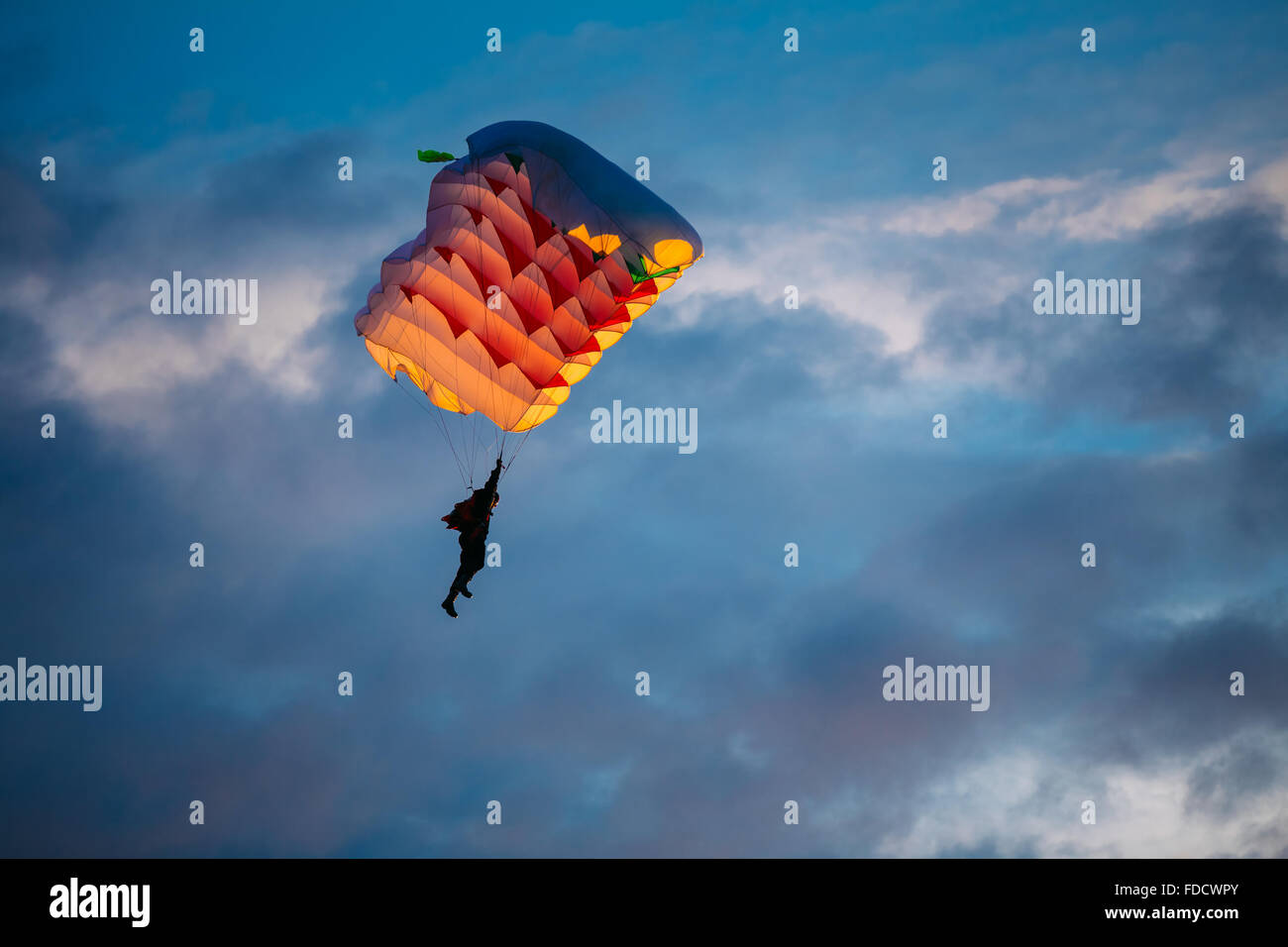 Skydiver On Colorful Parachute In Sky. Active Hobbies Stock Photo