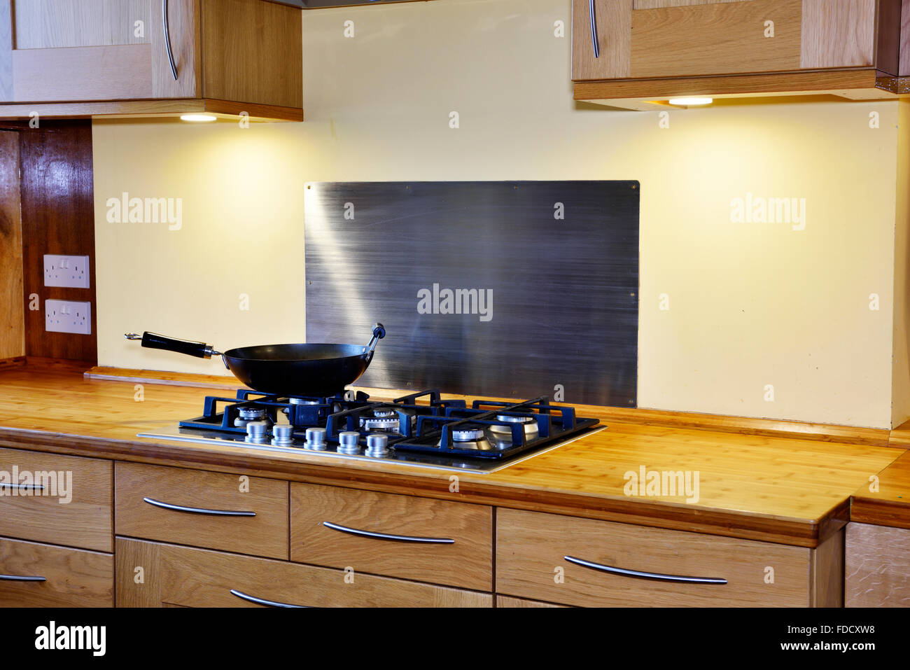 Modern kitchen with gas hob unit and bamboo worktop in England Stock Photo