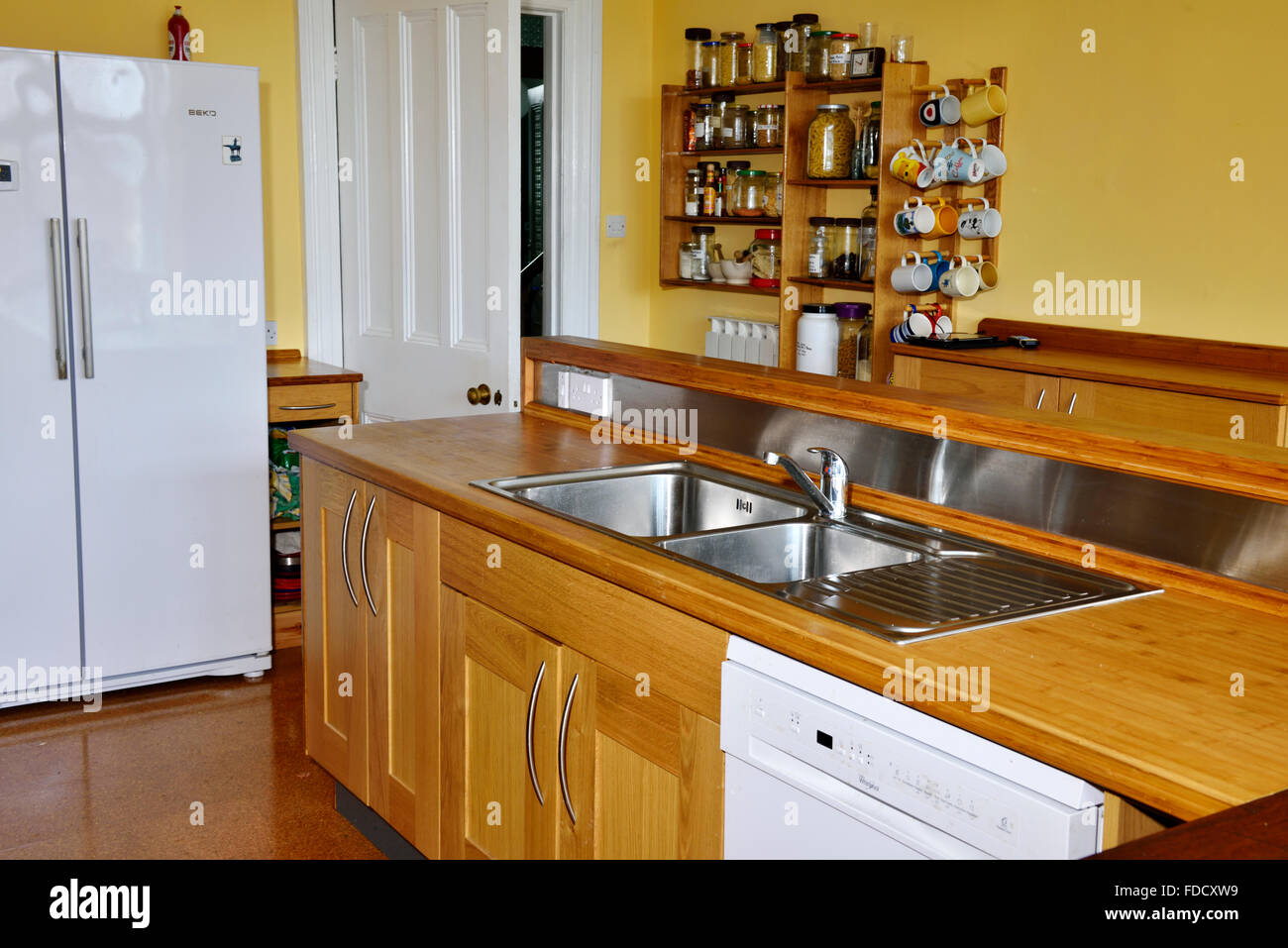 Refurbished kitchen with stainless steel sink in bamboo counter top, England Stock Photo