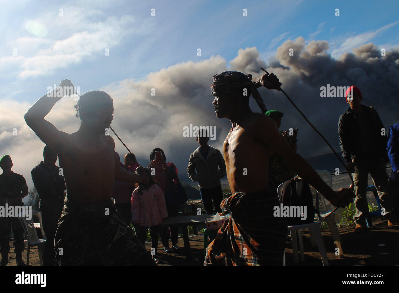 Probolinggo, East Java, Indonesia. 30th Jan, 2016. Tenggerese performs a traditional dance called 'Ujung-Ujungan' while Mount Bromo erupts in background. The ritual is one of the traditional dances by two men who alternated hitting the opponent by using rattan Palm branch. Credit:  Suryanto/ZUMA Wire/Alamy Live News Stock Photo