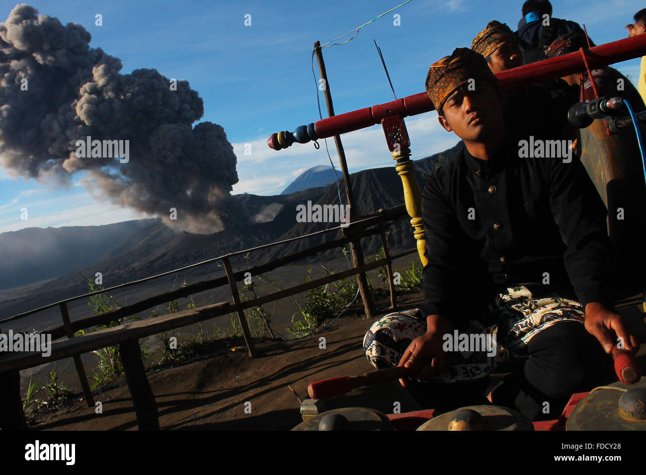 Probolinggo, East Java, Indonesia. 30th Jan, 2016. Tenggerese perform a traditional dance called 'Ujung-Ujungan' while Mount Bromo erupts in background. The ritual is one of the traditional dances by two men who alternated hitting the opponent by using rattan Palm branch. Credit:  Suryanto/ZUMA Wire/Alamy Live News Stock Photo