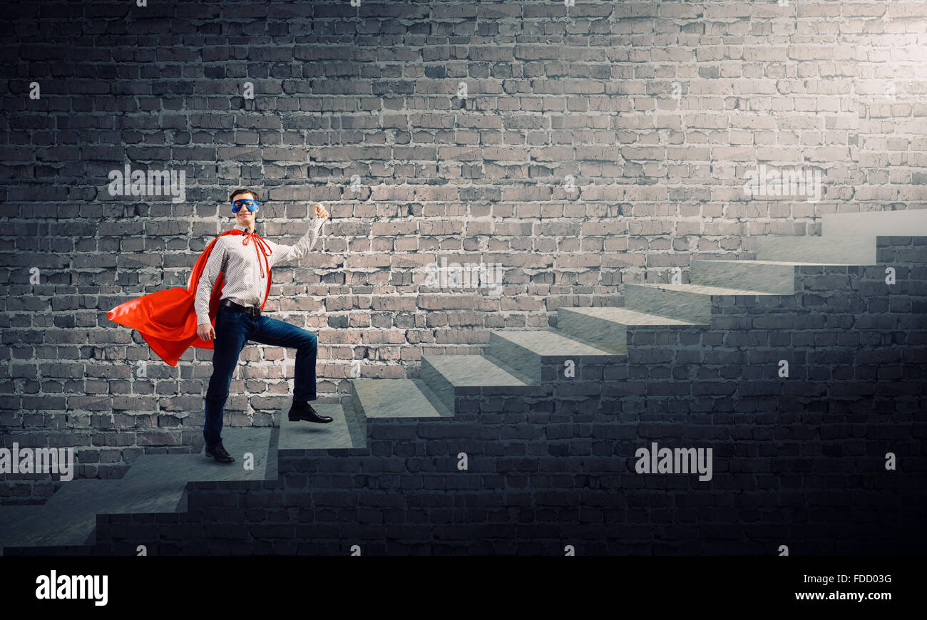 Young superman walking up the stair case Stock Photo - Alamy